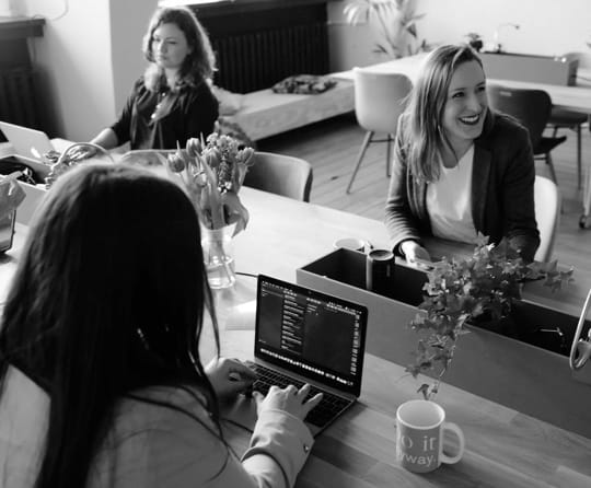 Three females working at their laptops inside an office